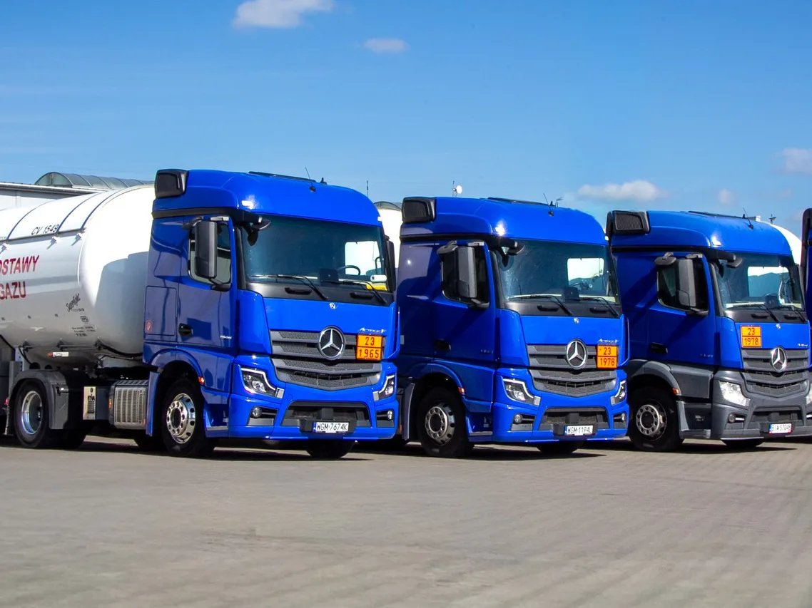 Rząd ciągników Mercedes-Benz Actros na placu, pierwszy z naczepą-cysterną PAKAR